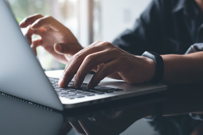 A person typing on a laptop