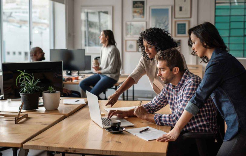 A group of people having a discussion about something on a computer